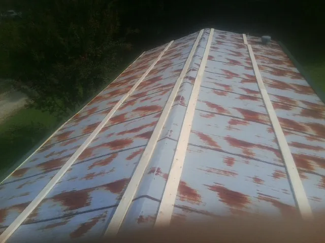 Rusted metal roof panels with new wood purlins before replacement — Storm Damage Roof Repair in Castleton by Roofing Brothers