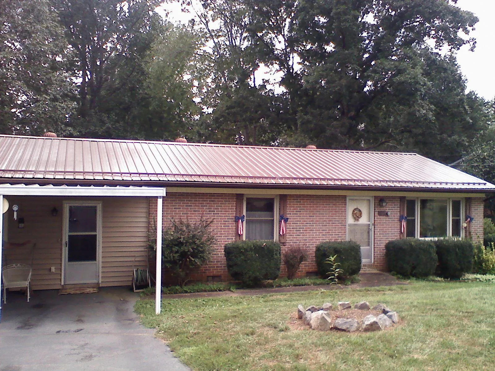 Bronze metal roof and carport on a brick ranch home — Roof Repair work by our crew in Castleton